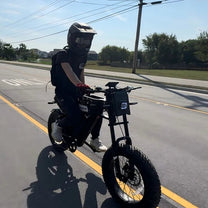 Uomo alla guida della fat bike elettrica VARUN X-Plorer Raptor con il casco su strada