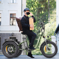 Uomo alla guida del triciclo elettrico Hidoes ET1 in città