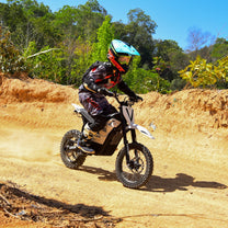 Pilota con la moto da cross elettrica Vipcoo H2 in fuoristrada su terreno sabbioso