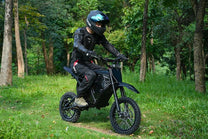 Pilota con la moto da cross elettrica Vipcoo H3 in fuoristrada nel bosco