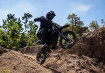Pilota con la moto da cross elettrica Vipcoo H3 in fuoristrada su un prato