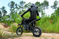 Pilota con la moto da cross elettrica Vipcoo H3 in fuoristrada nel bosco