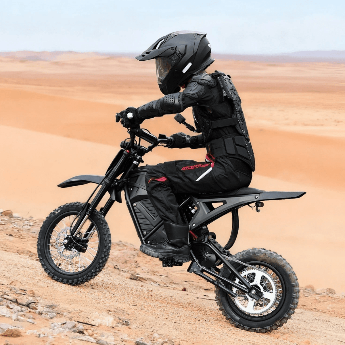 Pilota con la moto da cross elettrica Vipcoo H3 in fuoristrada su terreno sabbioso