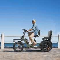 Persona alla guida del triciclo elettrico VIPCOO R1 in riva al mare