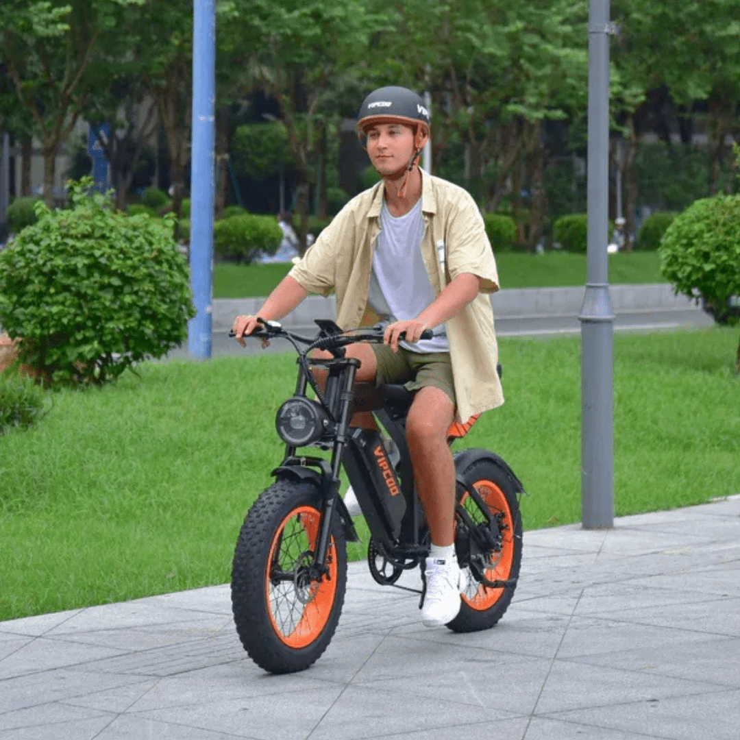 Uomo alla guida della fat bike elettrica VIPCOO VM6 con il casco in un parco
