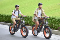 Due persone con la fat bike elettrica VIPCOO VM6 con il casco in un parco