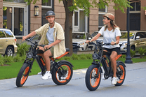 Due persone con la fat bike elettrica VIPCOO VM6 con il casco in una strada