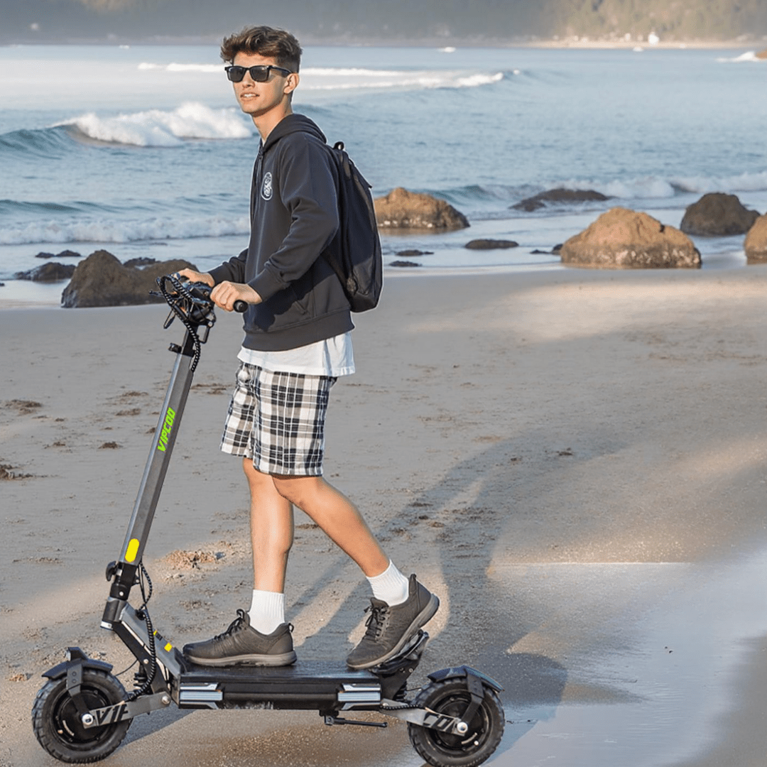 Uomo alla guida del monopattino elettrico VIPCOO VS6 in riva al mare