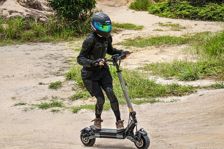 Persona alla guida del monopattino elettrico VIPCOO VS6 Pro su un sentiero
