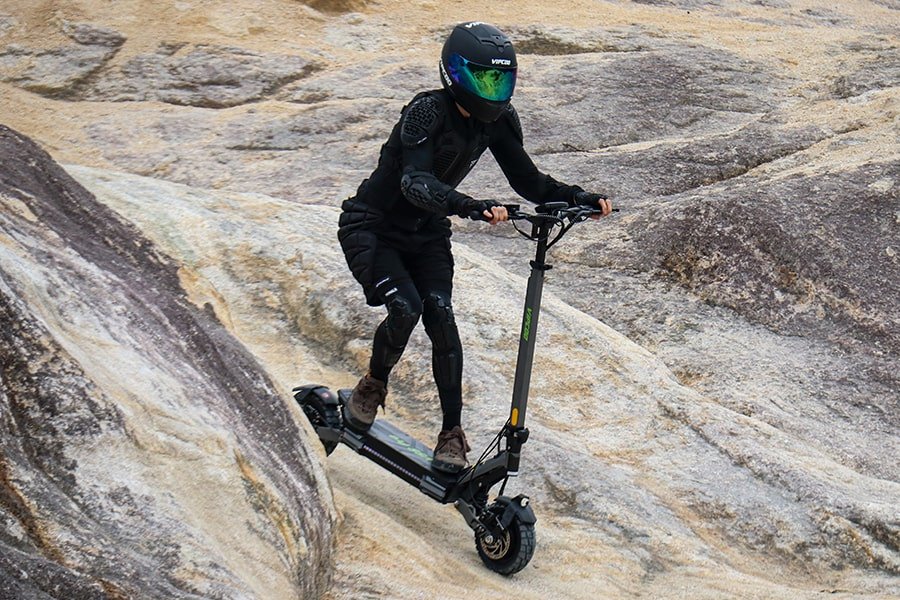 Persona alla guida del monopattino elettrico VIPCOO VS6 Pro su un sentiero