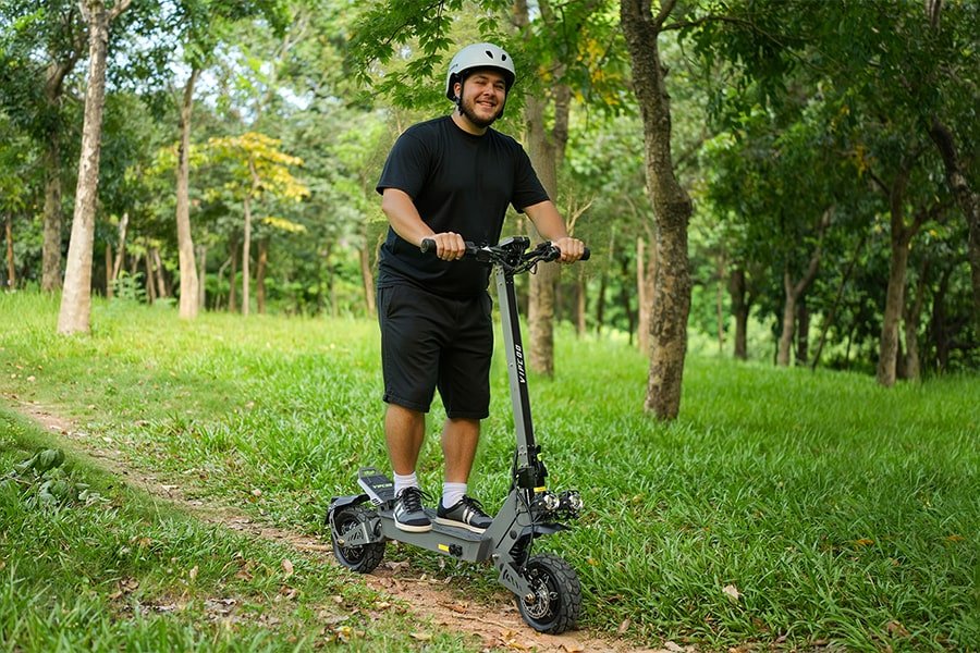 Uomo in piedi con il monopattino elettrico VIPCOO VS9 in un parco