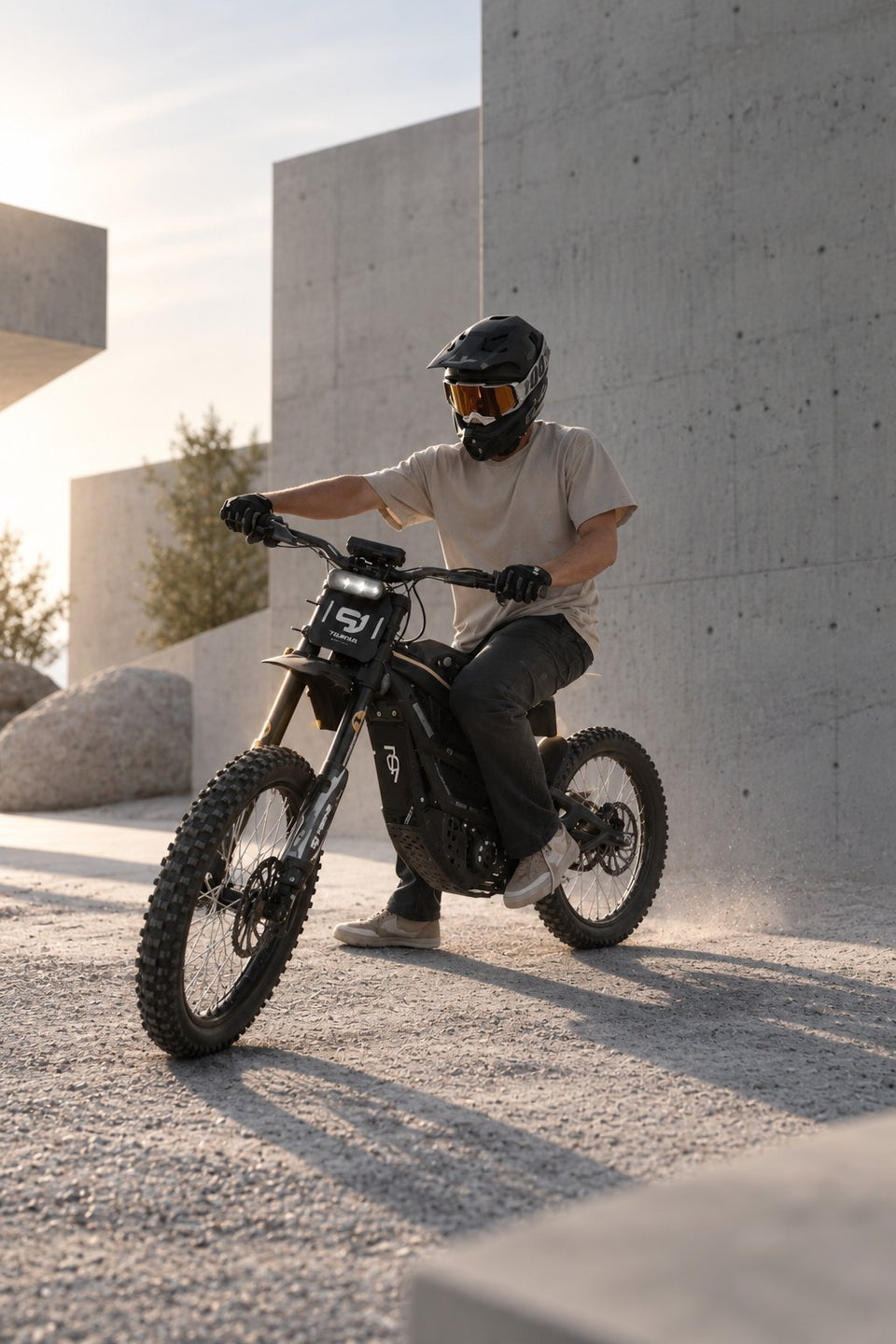 Moto elettrica da cross Wheelyshop – pilota con casco integrale davanti a un’architettura moderna in cemento
