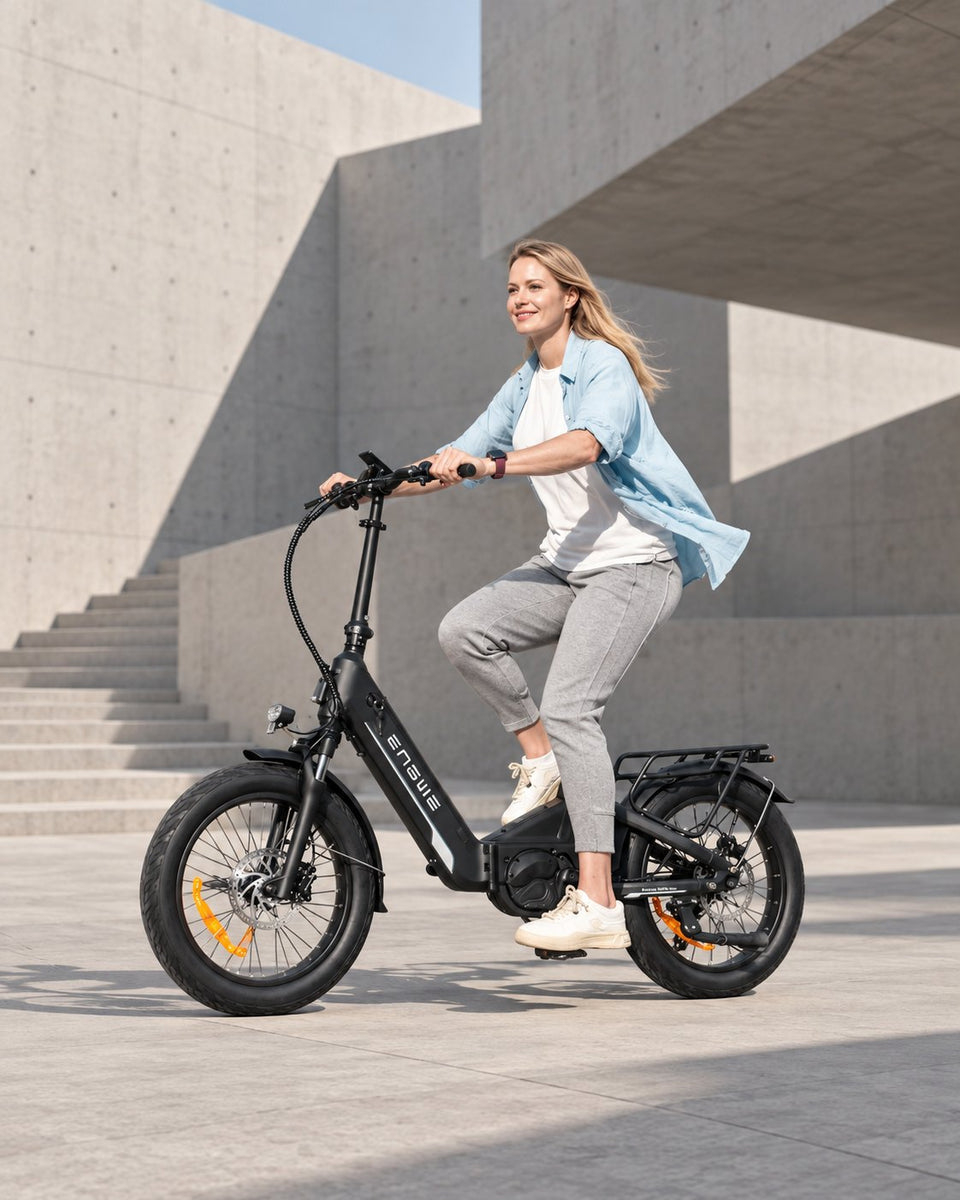 Bici elettrica Wheelyshop – ciclista su una bici pieghevole ENGWE davanti a un’architettura moderna in cemento