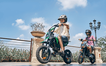 Persona alla guida della moto da cross elettrica Wheely A14 in città in gruppo