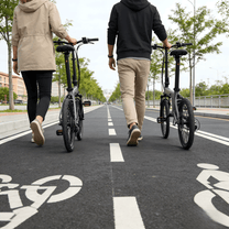 Due persone con la bici elettrica pieghevole YANGOR H19 in colore grigio su un vialetto