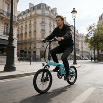 Uomo alla guida della bici elettrica pieghevole YANGOR H19 in curva in città in colore azzurro