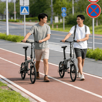 Due persone con la bici elettrica pieghevole YANGOR H19 in colore beige su un vialetto