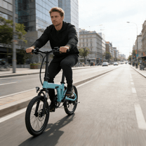 Uomo alla guida della bici elettrica pieghevole YANGOR H19 di fronte in città in colore azzurro