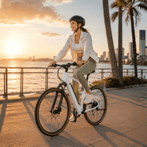 Donna alla guida della bici elettrica YANGOR H700 in colore bianco al tramonto