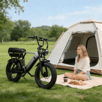 Persona seduta accanto alla fat bike elettrica YANGOR Y20 Pro in colore nero su un prato