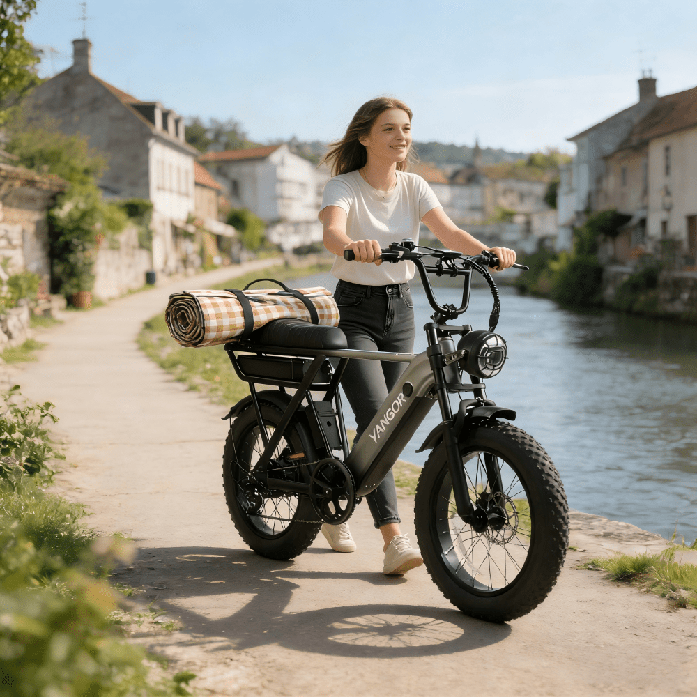 Donna alla guida della fat bike elettrica YANGOR Y20 Pro in colore nero su un vialetto