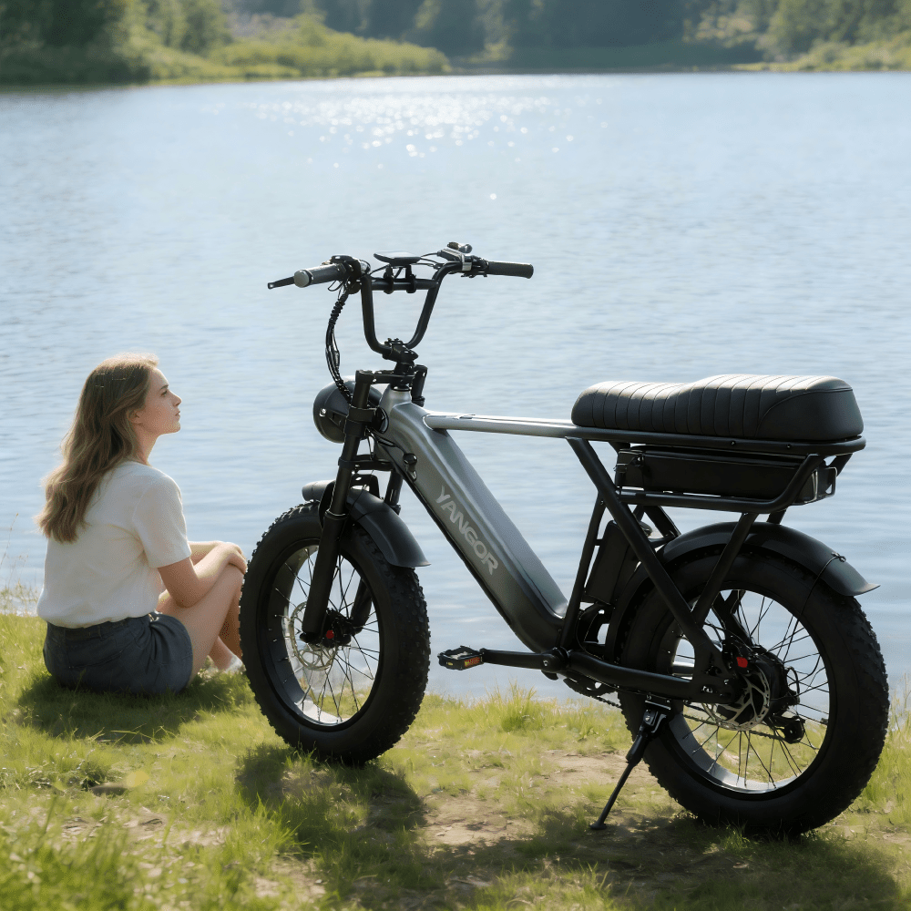 Persona seduta accanto alla fat bike elettrica YANGOR Y20 Pro in colore nero in riva al mare