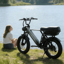 Persona seduta accanto alla fat bike elettrica YANGOR Y20 Pro in colore nero in riva al mare