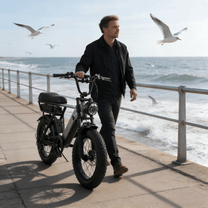 Uomo che passeggia con la fat bike elettrica YANGOR Y20 Pro in colore nero in riva al mare